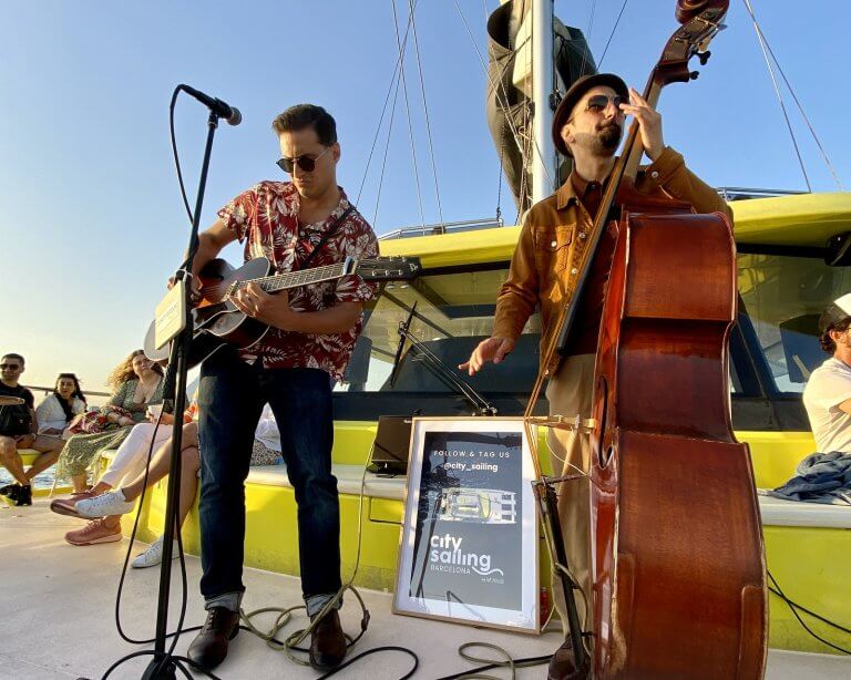 2 persons making music on a catamaran in Barcelona.