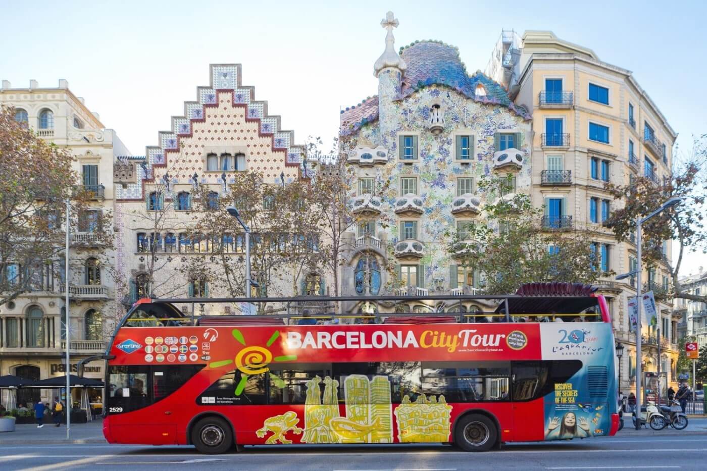 A Hop-on-Hop-off Bus passing infront of Casa Batlló in Barcelona.