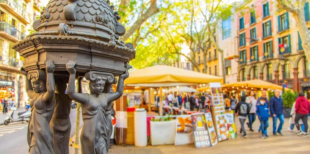 Famous La Rambla Street in barcelona with a stand selling souvenirs.