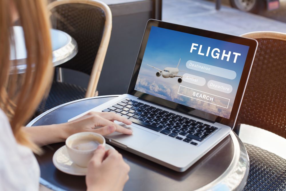 A person searches for flights online on their laptop