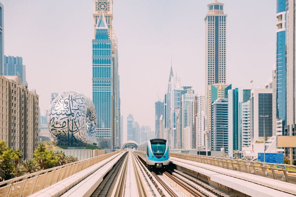 Monorail subway trains run between glass skyscrapers in Dubai.
