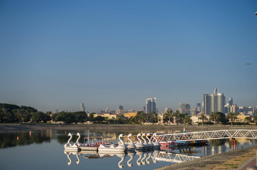 Park with a lake and some boats outside of Dubai.