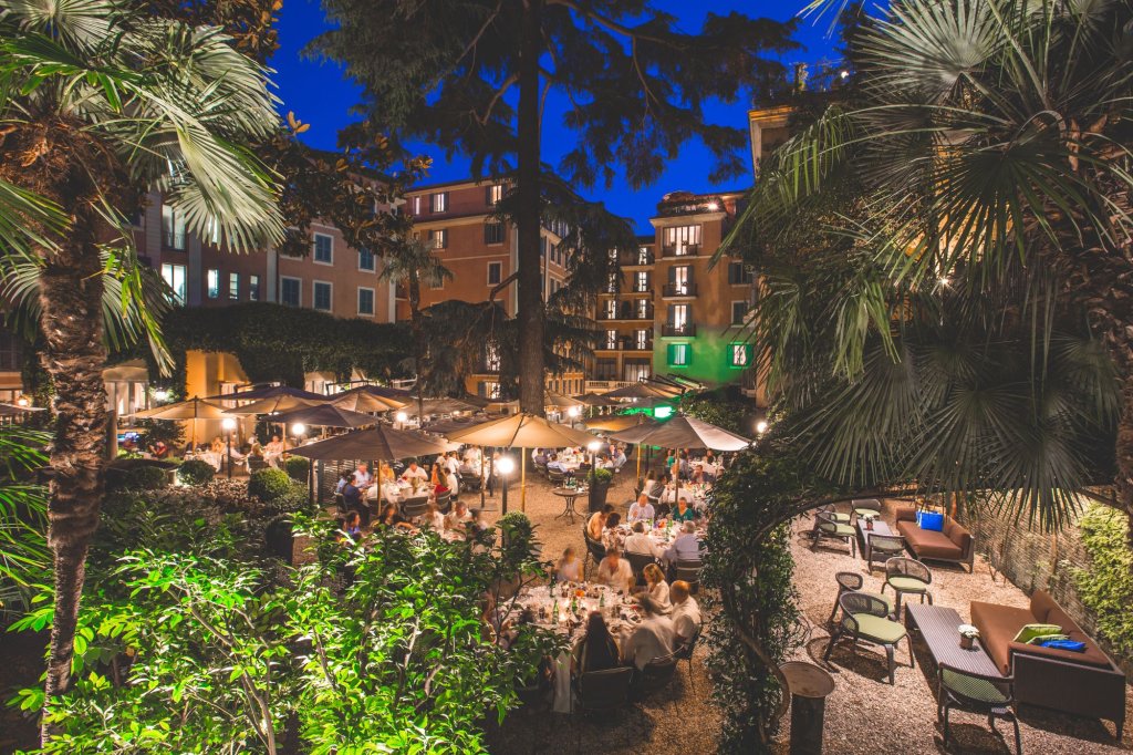 A huge outdoor terrace in Trastevere Rome during the night with lots of lights.