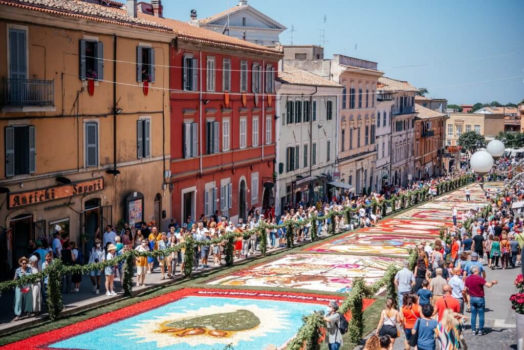 The flower festival in Italy with decorated, colorful flower carpets and many spectators.