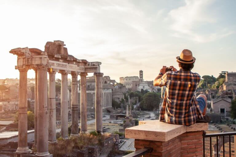 A young man looks out over the Roman Forum in Rome.
