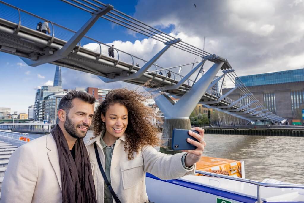 Thames sightseeing cruise with a couple taking a selfie.