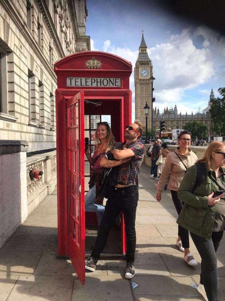 A couple pose in the famous red telephone box in front of Big Ben in London.