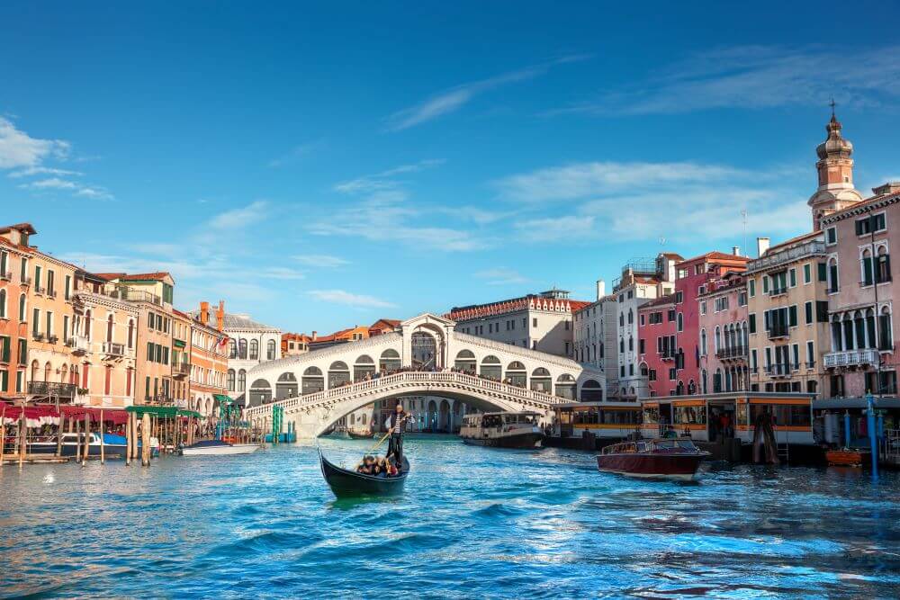 View of Rialto Bridge with a gondola ride on the Gran Canal.