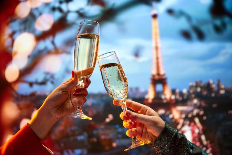 Two champagne glasses in front of the Eiffel Tower