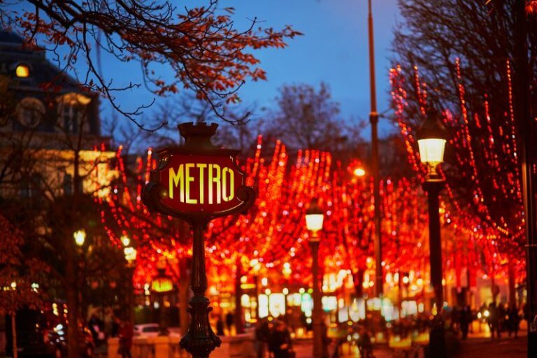 Metro sign and seasonal illumination of trees