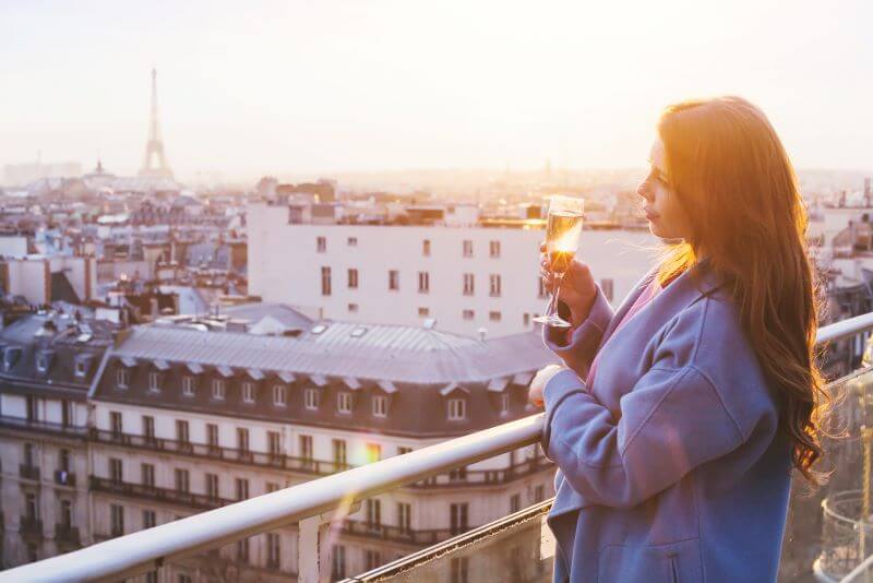 Woman with champagne on balcony in Paris